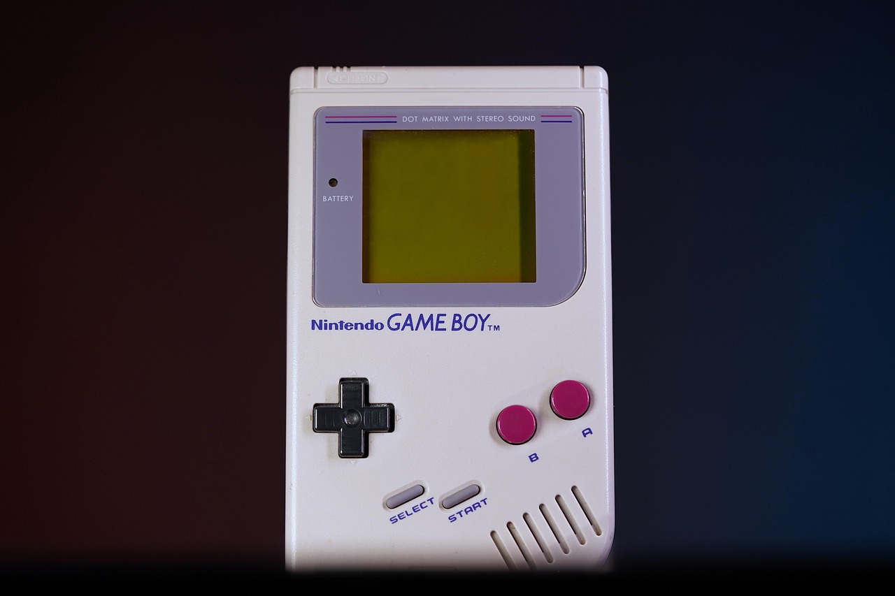 Game Boy originale su un tavolo con giochi vintage, evidenziando il suo valore attuale nel mercato collezionistico.