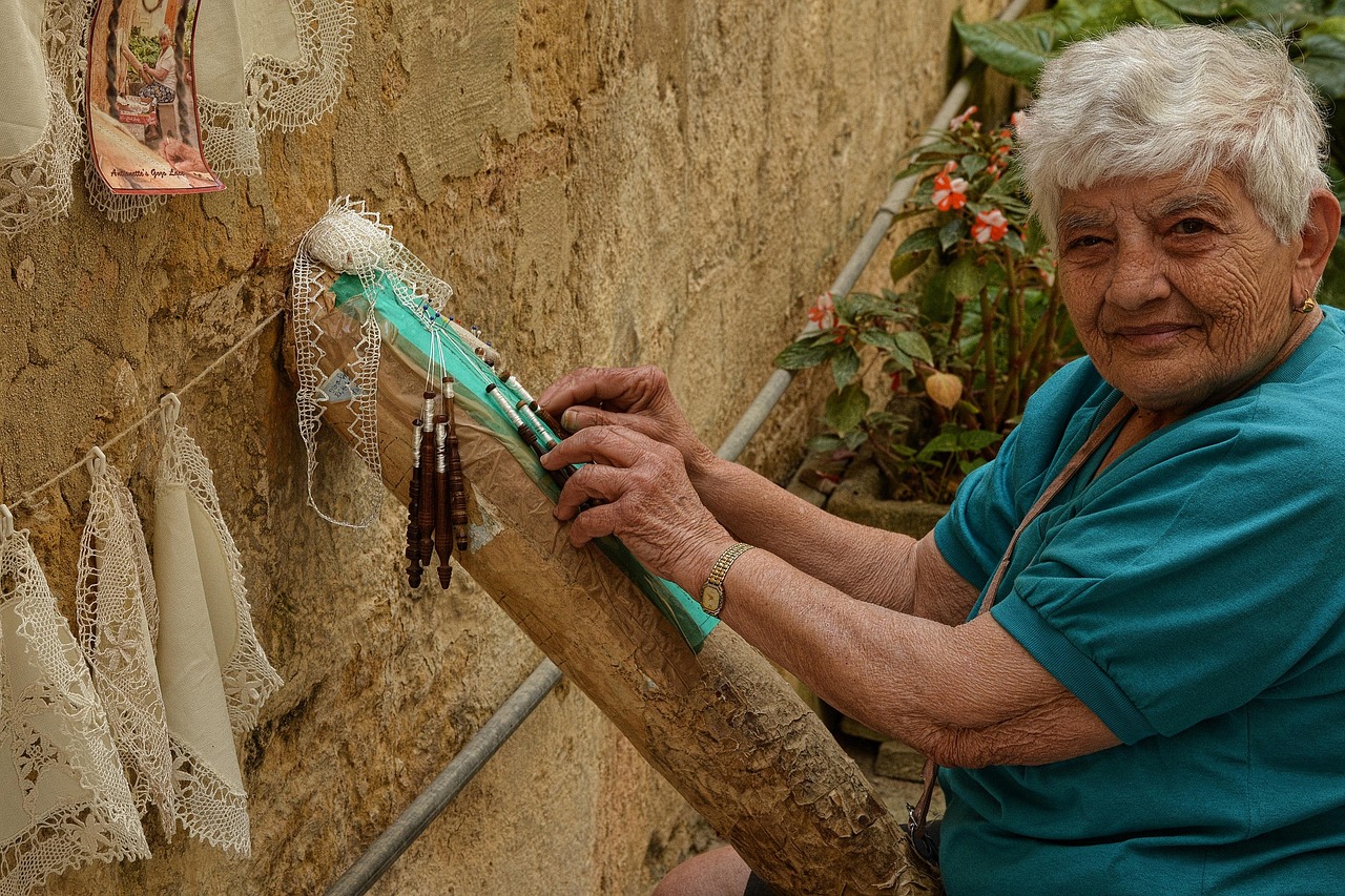 Vecchi merletti e pizzi della nonna esposti su un tavolo, simbolo di artigianato prezioso e tradizione.