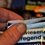 Tabaccaio che mostra gratta e vinci con schede vincenti in evidenza.