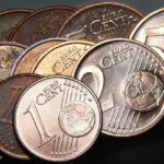 Moneta da 1 centesimo rara, valutata 500.000 euro, in primo piano su sfondo neutro.