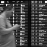 Due persone sorridenti controllano offerte di viaggi last minute su un laptop.